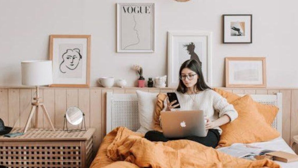 a woman sitting in bed exploring environmentally friendly furniture.